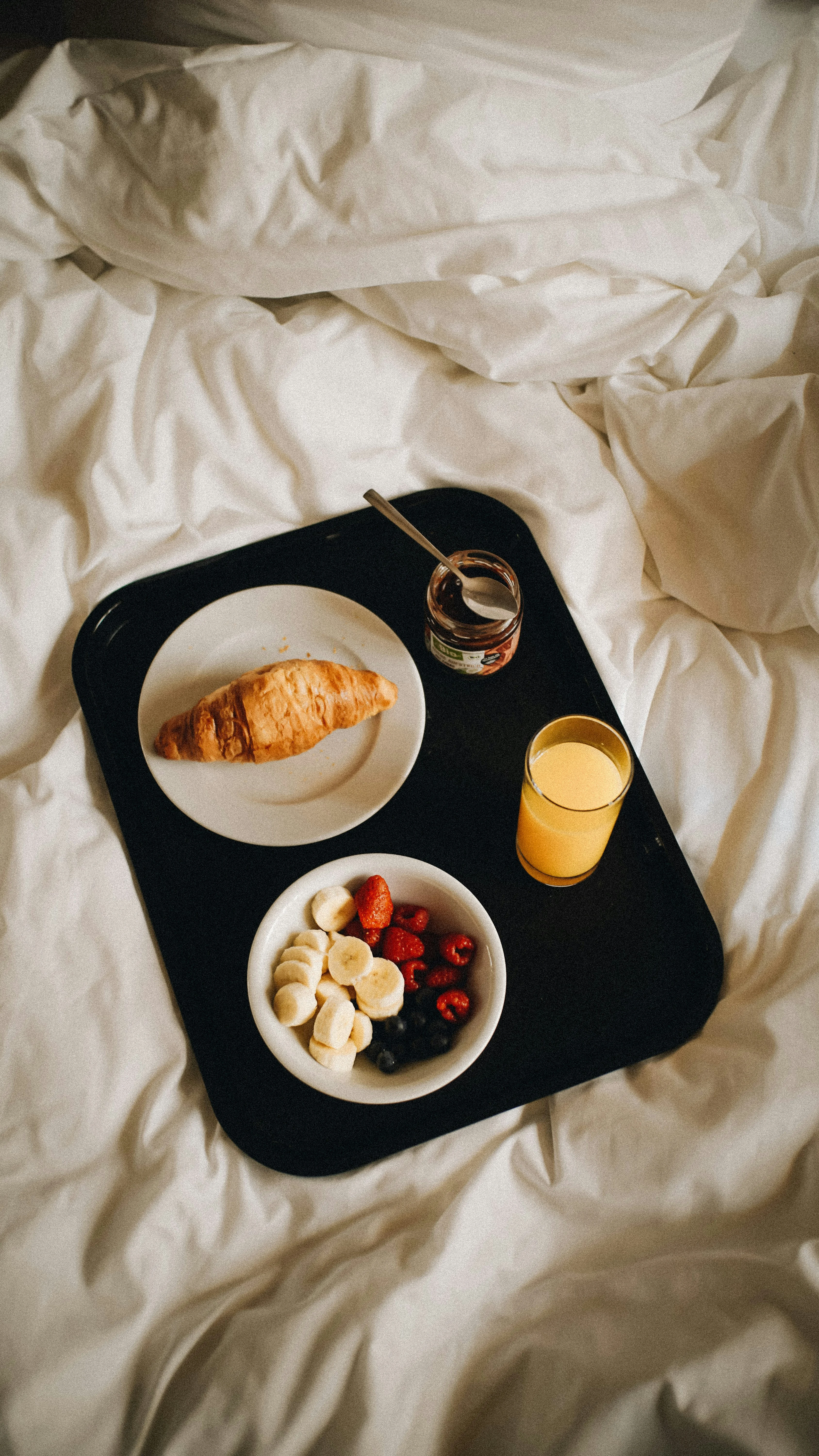 Breakfast tray on linen sheets